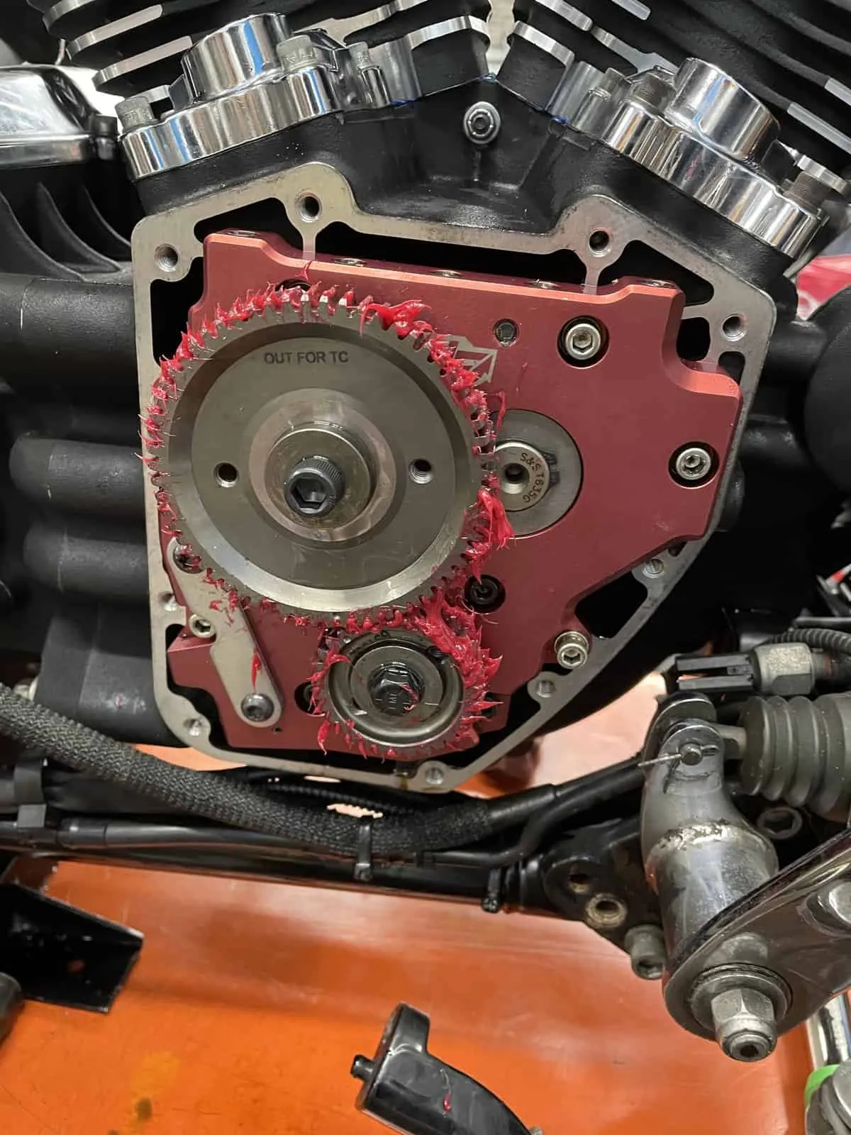 Harley engine with the cam cover off, showing an upgraded cam plate